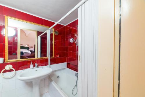 a red bathroom with a sink and a shower at Palazzo Ducale Sangiovanni in Alessano
