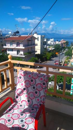 a chair on a balcony with a view of a city at Hotel Aidipsos in Loutra Edipsou