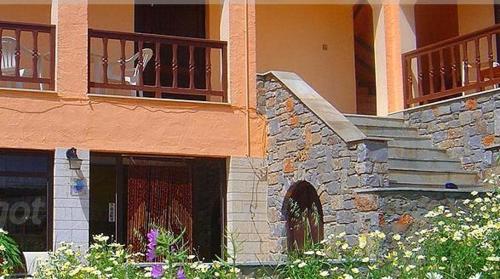 a stone building with a balcony and a staircase at House Margot in Palekastron