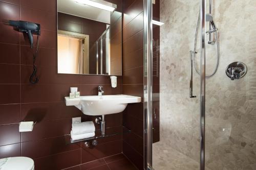 a bathroom with a sink and a shower at Hotel Rossini in Pesaro