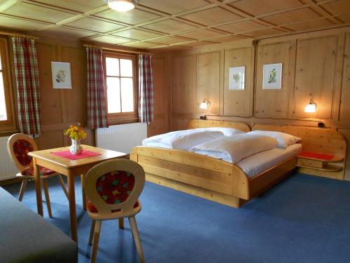 a bedroom with a large bed and a table at Ferienhaus Pfeifer in Gaschurn