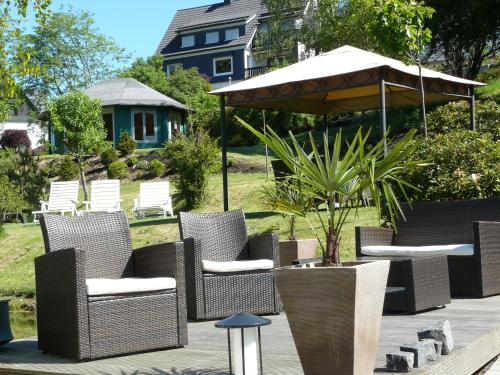 a group of chairs and an umbrella on a patio at Landhaus Silberberg in Winterberg