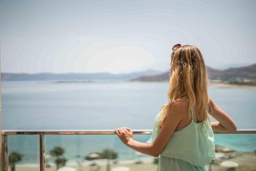 a woman standing on a balcony looking at the water at Balos Beach in Kissamos
