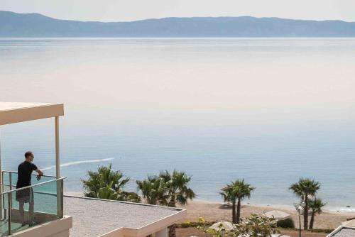 a man standing on a balcony looking at the water at Balos Beach in Kissamos
