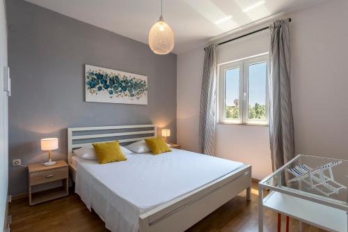 a bedroom with a white bed and a window at Marijana Bol Apartments in Bol
