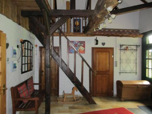 a room with a wooden staircase and a stair case at Heuerhaus Gut Einhaus in Werlte