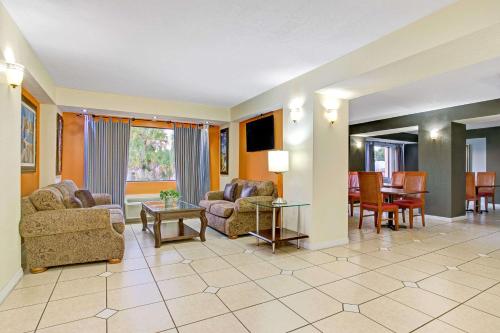 a living room with two couches and a dining room at Days Inn & Suites by Wyndham Tampa - Ybor City in Tampa