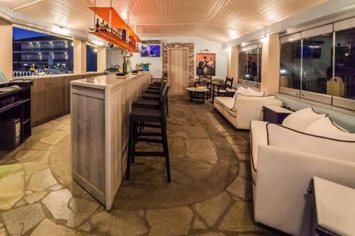 a bar in a restaurant with white chairs and tables at Sintrivanis Resort Beach in Paralía Skotínis