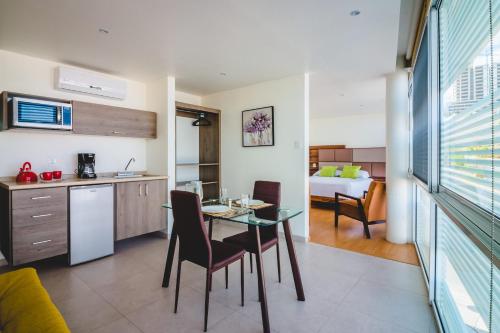 a kitchen and living room with a table and chairs at Millenium Plaza & Suites in San Luis Potosí