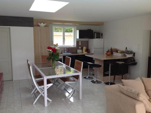 une cuisine avec une table et des chaises dans une pièce dans l'établissement La maison de Brijy, à Pleslin-Trigavou