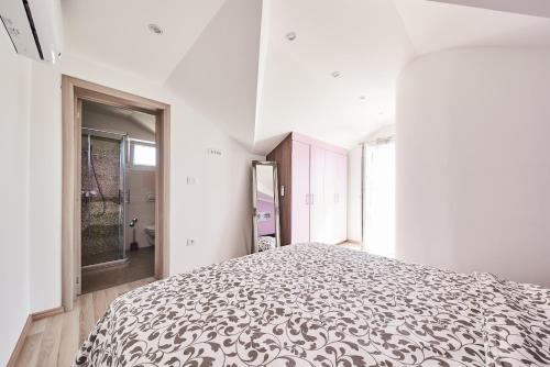 a bedroom with a large bed in a white room at Apartment Tamara in Umag