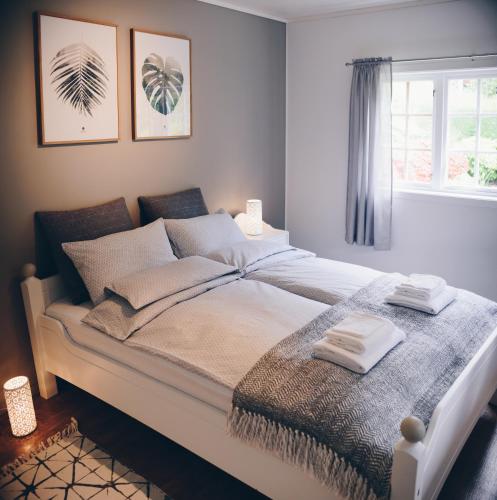 a bedroom with a large bed with two towels on it at Dalhus - House with jacuzzi in Norddal