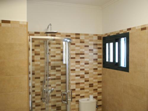 プエルト・デル・カルメンにあるApartamentos Colombia Ap 5のバスルーム(シャワー、トイレ付)、窓が備わります。