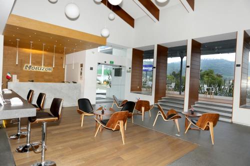 a restaurant with chairs and tables and a counter at Hotel Horizon & Convention Center in Morelia