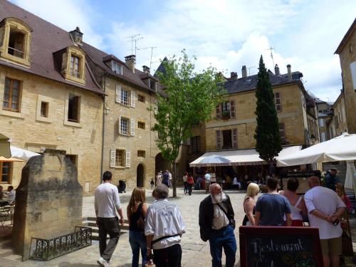 Un groupe de personnes marchant dans une rue dans l'établissement Le Porche de Sarlat, à Sarlat-la-Canéda