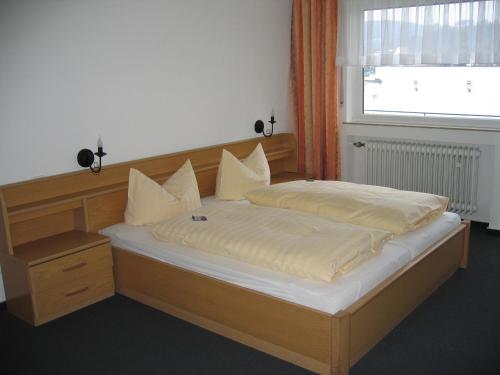a bedroom with a large bed with white sheets and a window at Hotel Zur Kripp in Koblenz