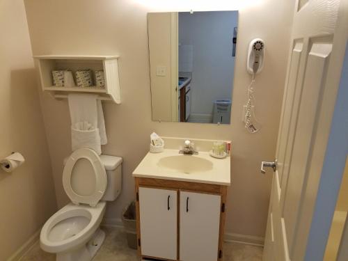 a bathroom with a toilet and a sink and a mirror at Affordable Suites Florence in Florence