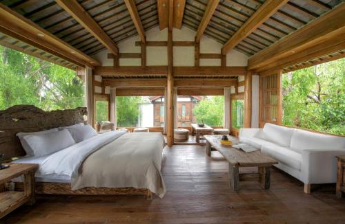 ein Schlafzimmer mit einem großen Bett und einem Sofa in der Unterkunft 吾爱堂 in Lijiang