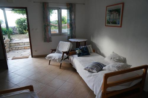 sypialnia z dwoma łóżkami i krzesłem w obiekcie Apartment Stiniva w Hvarze