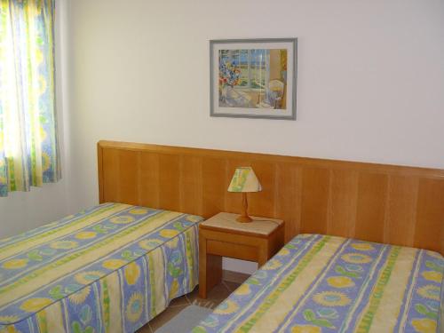 a bedroom with two beds and a lamp on a table at Quinta Das Figueirinhas & Quintinha Village in Armação de Pêra