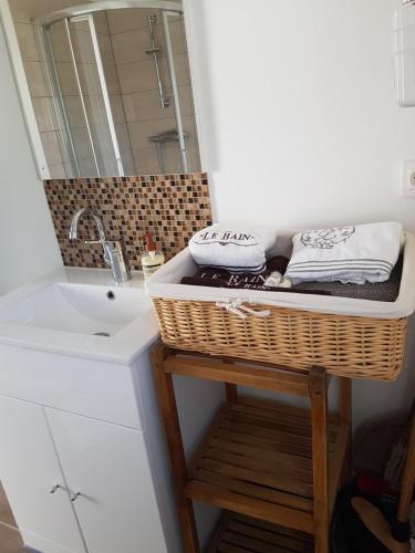 a bathroom with a sink and a basket with towels at villa donia in Corte