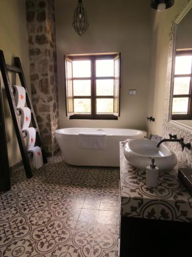 a bathroom with a bath tub and a sink at Hacienda Tovares in Cadereyta de Montes
