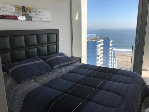 Schlafzimmer mit einem Bett und Strandblick in der Unterkunft Apartamento Playa y Casino in Coquimbo
