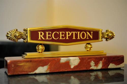 a sign that says reception sitting on top of books at Hotel Lido - Beach and Palace in Bolsena