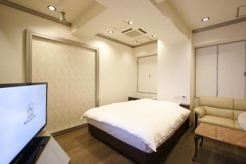 a bedroom with a bed and a flat screen tv at Noa Hotel Toyotaminami (Adult Only) in Anjo