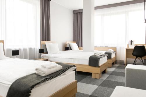 2 łóżka w pokoju hotelowym z oknami w obiekcie Waw Hotel Airport Okęcie w Warszawie
