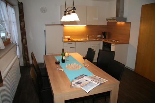 una cocina con una mesa de madera y una botella de vino en Ferienwohnung Rahm en Schwendau