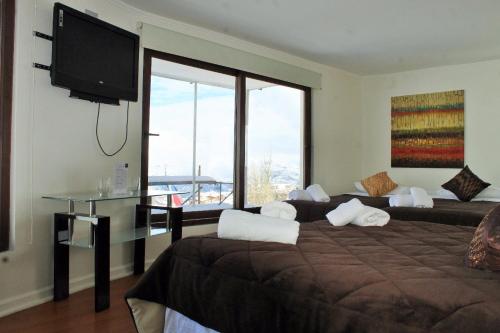 a bedroom with a large bed and a flat screen tv at Hotel HF in Farellones