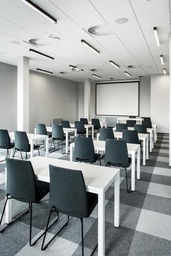 Una sala de conferencias con mesas, sillas y una pizarra. en Waw Hotel Airport Okęcie, en Varsovia