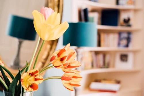 a vase filled with orange flowers in a room at Castel Jolly in Rennes