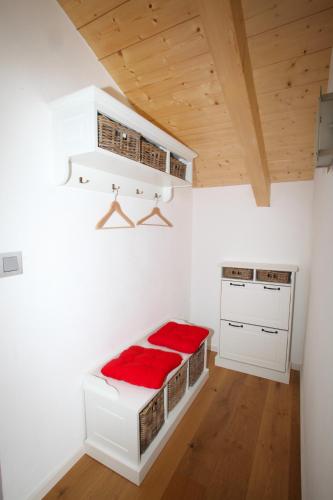 a bedroom with white walls and a bed with red sheets at Landhaus Constantin Luxus-Appartments in Berchtesgaden