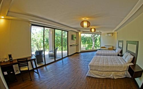 a bedroom with two beds and a living room at Nammbú Beach Front Bungalows in Sámara