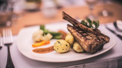 a plate of food with meat and vegetables on a table at Aria Exclusive Villas & SPA in Seminyak