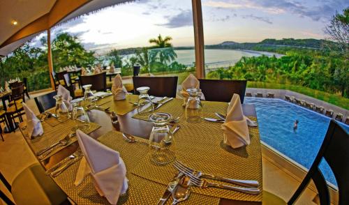 a restaurant with a table with a view of a pool at Nammbú Beach Front Bungalows in Sámara