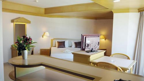 a hotel room with a bed and a desk with a mirror at City Beach Resort in Hua Hin