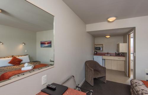 a hotel room with a bed and a mirror at Bella Vista Nelson in Nelson