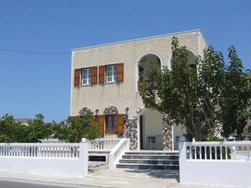 a house with a white fence in front of it at Margarita in Perissa