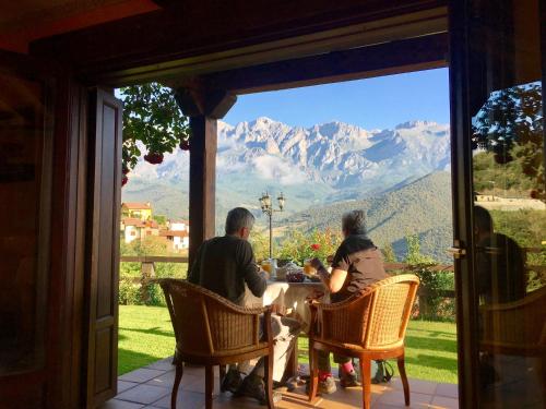 a group of people sitting at a table with a view of mountains at Posada El Bosque in Mieses
