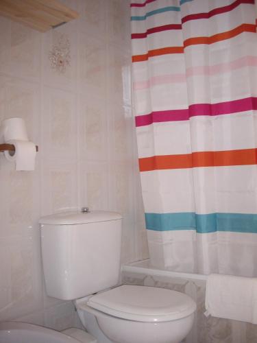 a bathroom with a toilet and a shower curtain at Hostal Mini Golf in Los Caños de Meca