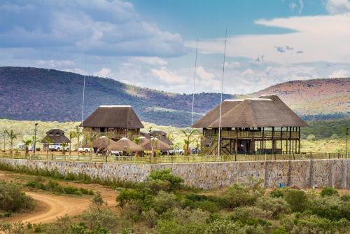 a group of huts in the middle of a field at Big Valley Game Lodge in Lobatse