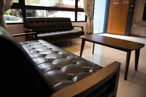 a living room with a leather couch and a table at Travel Mind in Hualien City