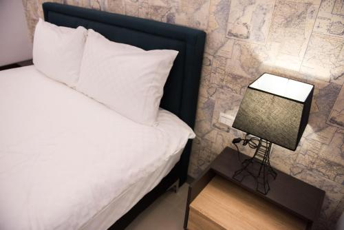 a bedroom with a bed and a side table with a lamp at Travel Mind in Hualien City