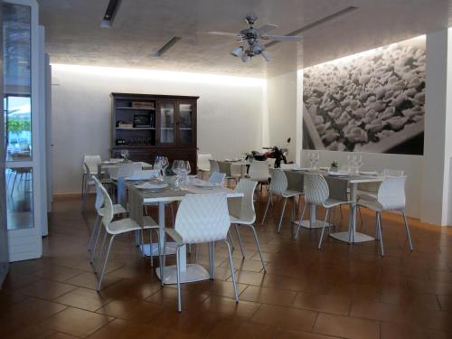 a dining room with white tables and white chairs at Albergo Al Cacciatore Tortellinando in Valeggio sul Mincio