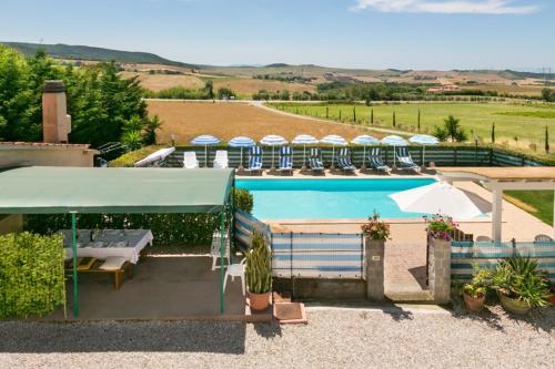 uma piscina com cadeiras e guarda-sóis num edifício em Agriturismo Case Nuove em Castellina Marittima