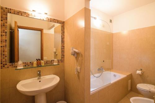 a bathroom with a sink and a toilet and a tub at Albergo Reggio in Reggio Emilia
