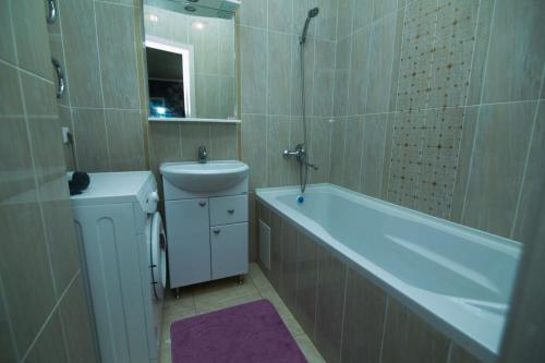 La salle de bains est pourvue d'une baignoire, de toilettes et d'un lavabo. dans l'établissement Apartments on 7/1 Sarayshyq, à Astana